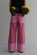 Pink and red striped wide-leg pants with an elastic waistband and flower-embellished back pockets. Perfect for warm days.