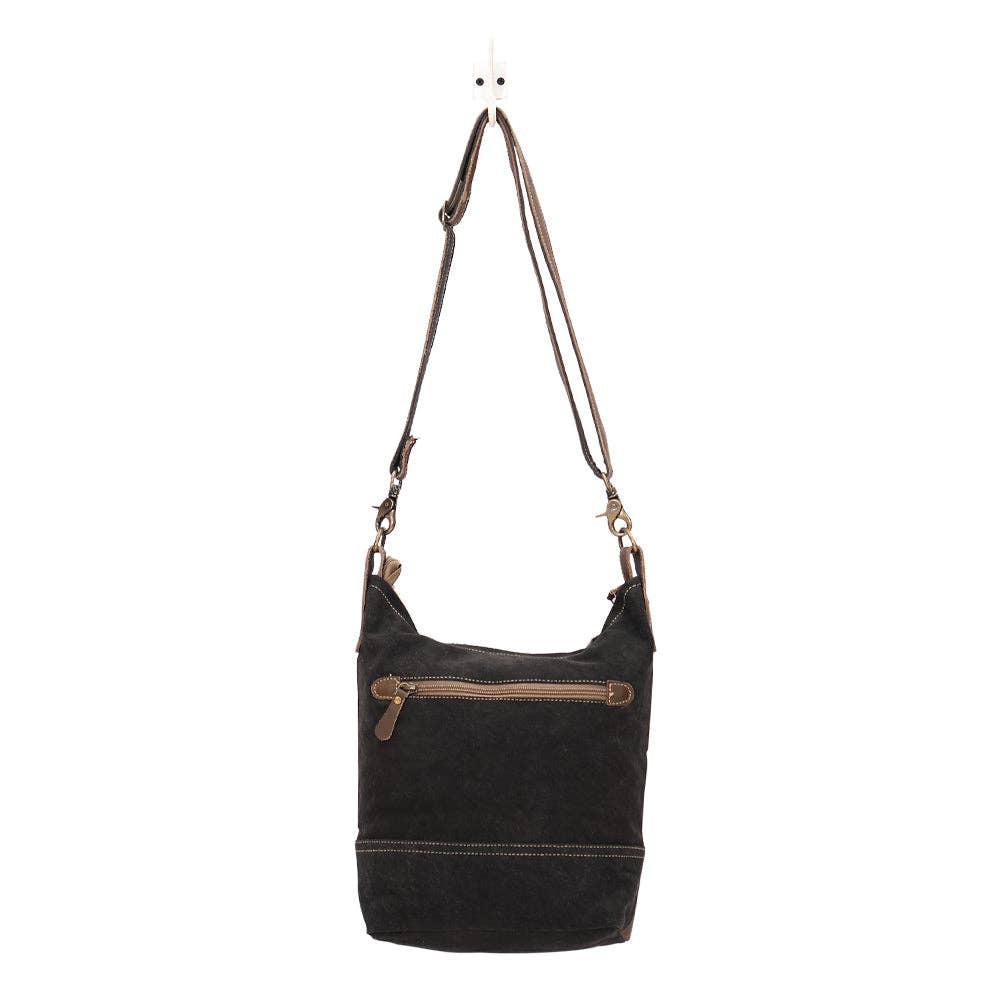 Shoulder bag with a zippered top and front pocket, showcasing its chic design and long shoulder strap.