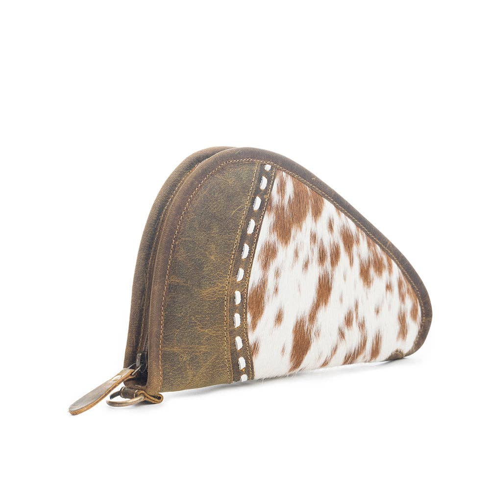 Compact gun case featuring a rounded shape, brown leather, and a stylish hairon section with zipper closure.