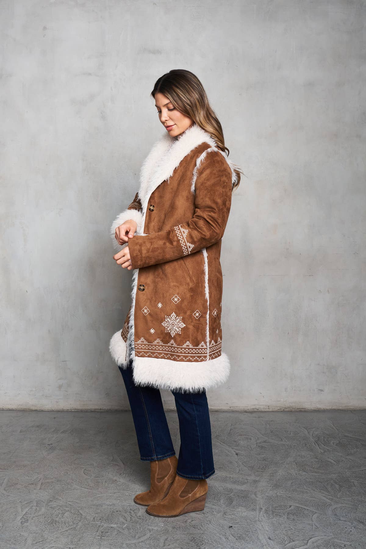 Faux suede camel coat featuring shearling trim, delicate embroidery, and inseam pockets for a stylish western look.