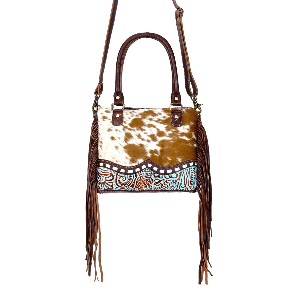 Chic brown hairon leather concealed carry bag with fringe detailing and adaptable straps for versatile carrying options.