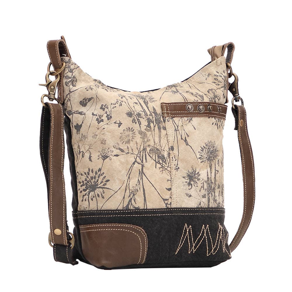 Floral canvas shoulder bag featuring a front pocket and a slouchy design, perfect for everyday use.