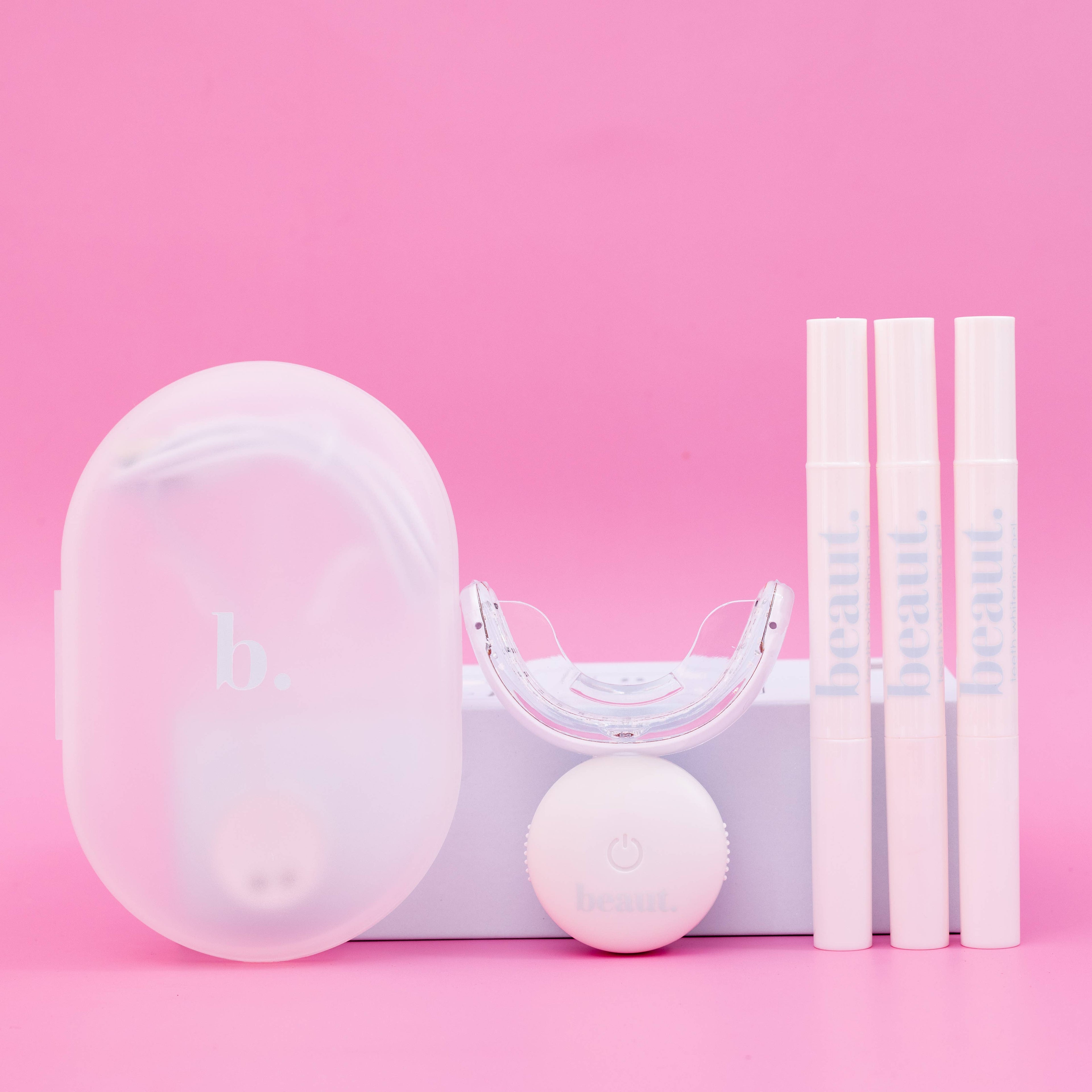 Compact case with a transparent lid, mouthpiece, and three tubes for the Cozy Kit, designed for oral care and whitening.