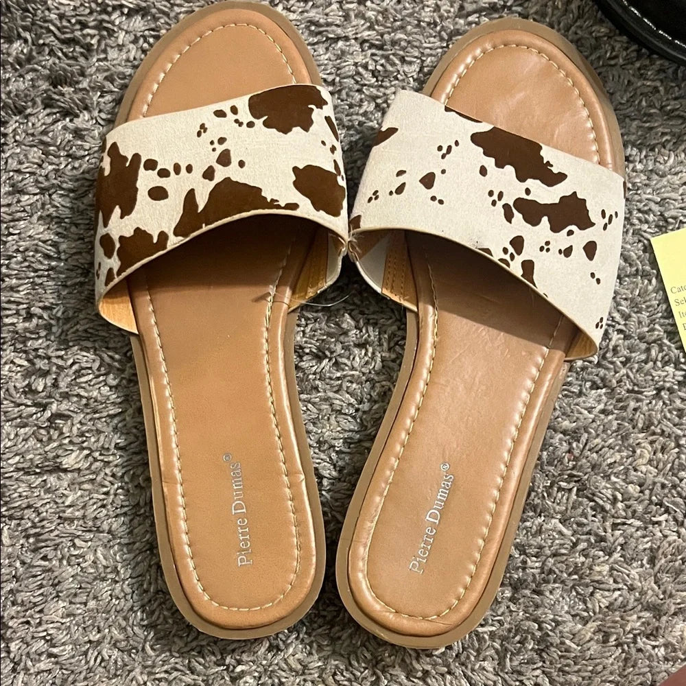 Brown and cream cow print sandals with a comfortable slip-on style, perfect for everyday wear.